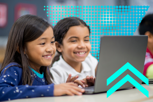 Two elementary school students use a laptop together. 